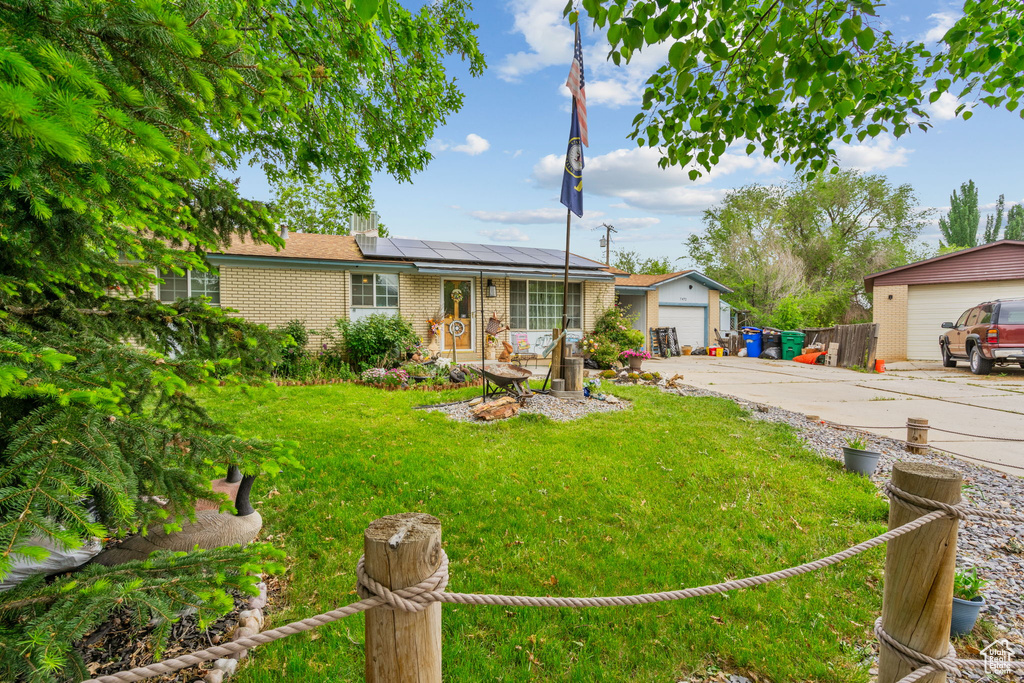 Ranch-style home with brick siding, solar panels, and a detached garage