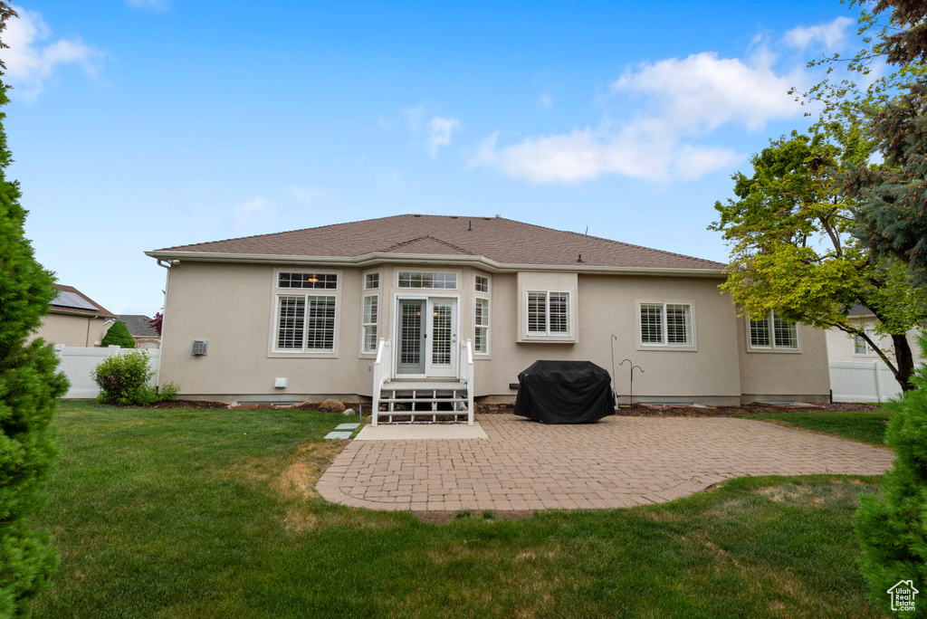 Rear view of house with stucco siding and a patio