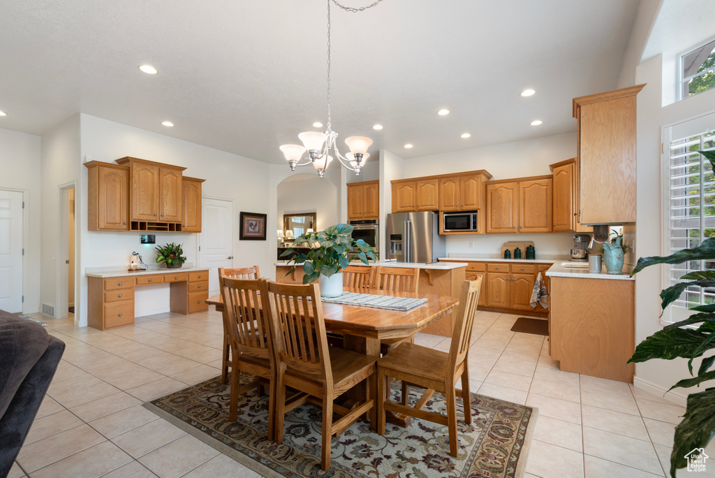Dining room with recessed lighting, light tile patterned floors, a chandelier, and arched walkways