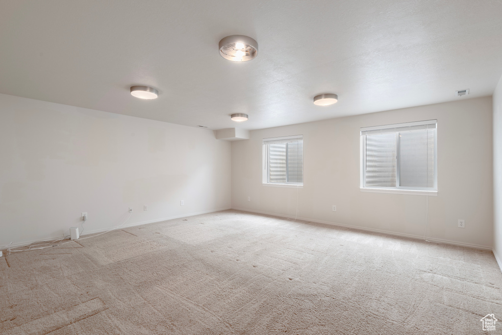 Spare room featuring carpet and baseboards