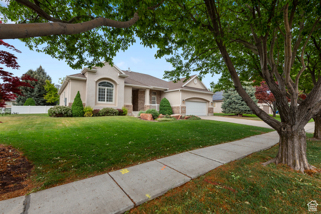 View of front of house featuring stucco siding, concrete driveway, and a garage