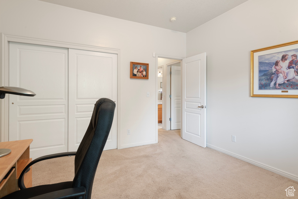 Home office with light carpet and baseboards