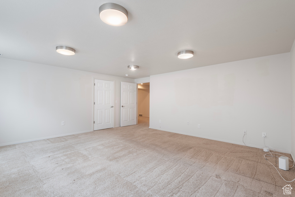 Spare room with light carpet and baseboards