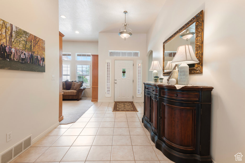Entryway with light tile patterned floors, baseboards, and recessed lighting