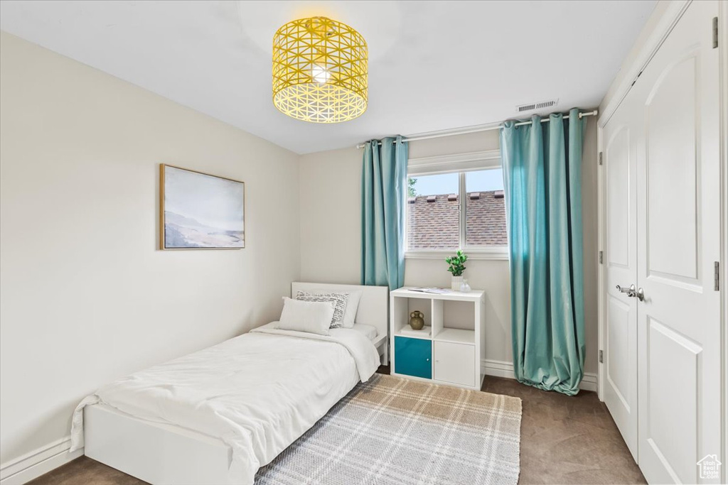 Carpeted bedroom featuring a closet and baseboards