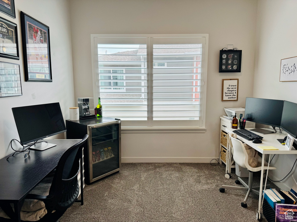 Carpeted home office featuring plenty of natural light and baseboards
