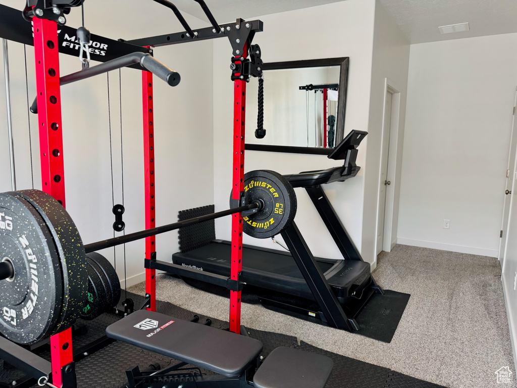 Exercise area with baseboards and carpet