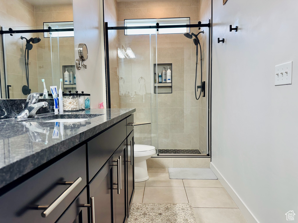 Full bathroom featuring toilet, a shower stall, tile patterned flooring, vanity, and baseboards