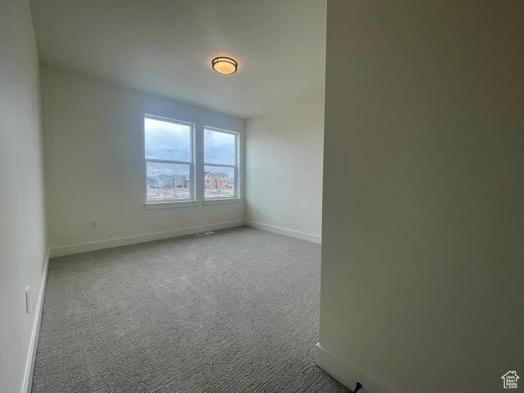 Carpeted empty room with baseboards