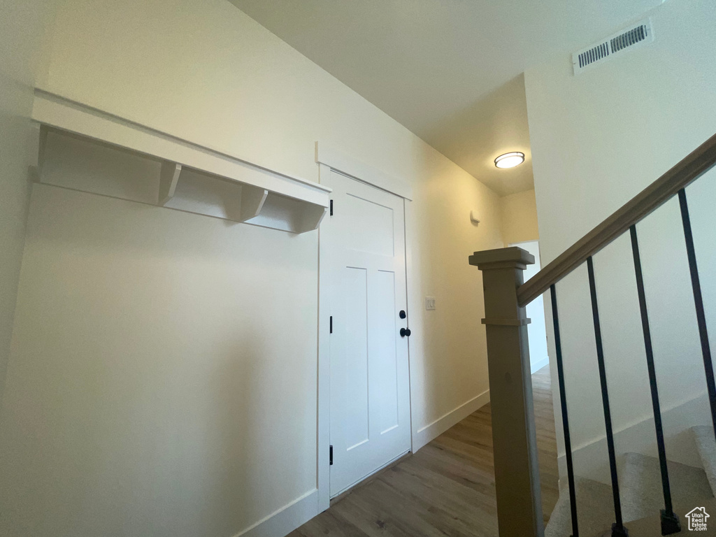Hallway featuring wood finished floors, stairs, and baseboards