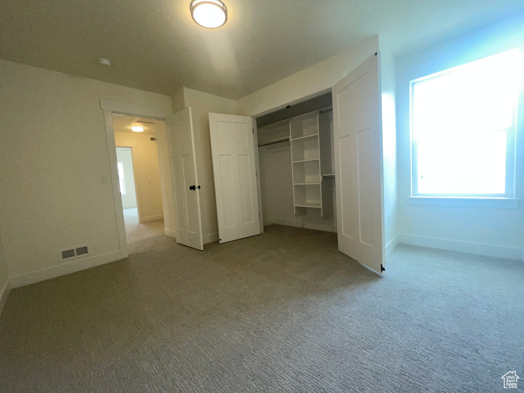 Unfurnished bedroom featuring carpet, a closet, and baseboards