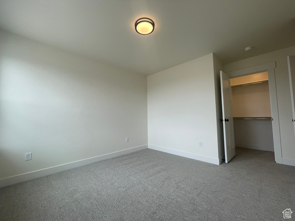 Unfurnished bedroom with baseboards, carpet, and a closet