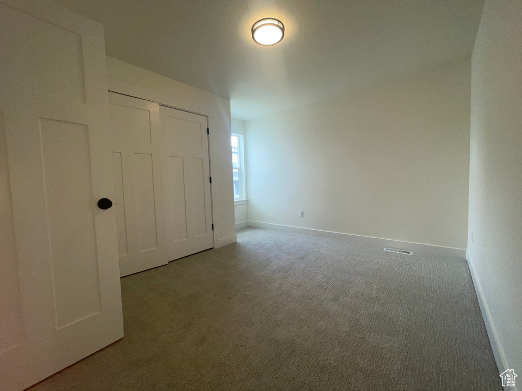 Unfurnished bedroom featuring carpet, baseboards, and a closet