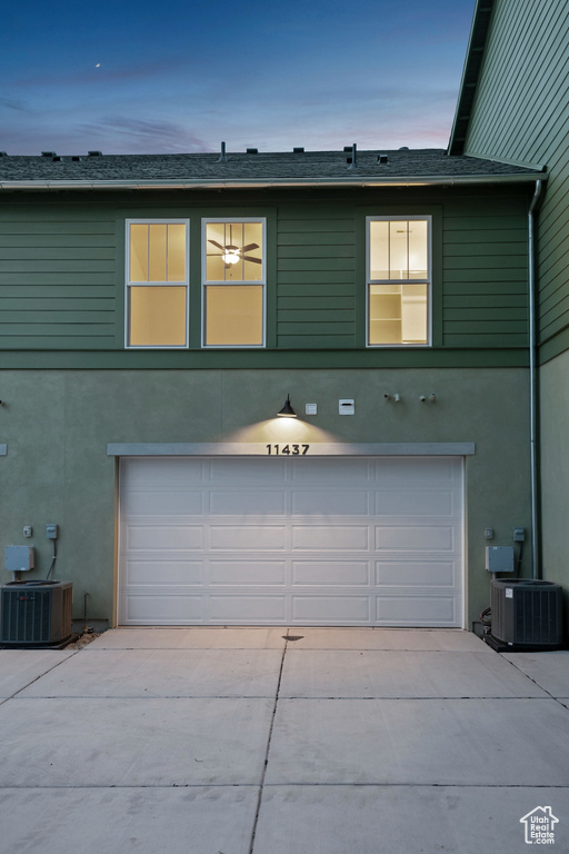 View of front of house with a garage, central AC, and driveway
