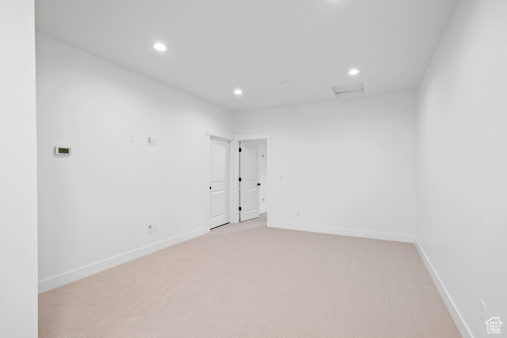 Empty room featuring light colored carpet, recessed lighting, attic access, and baseboards