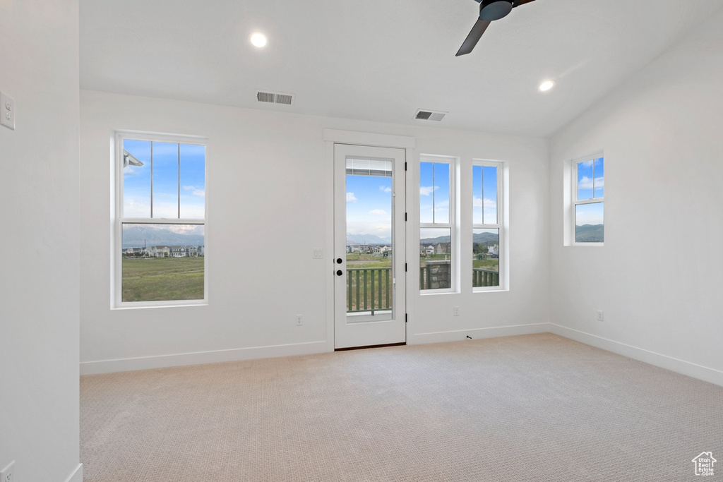 Empty room with healthy amount of natural light, baseboards, light carpet, a ceiling fan, and recessed lighting