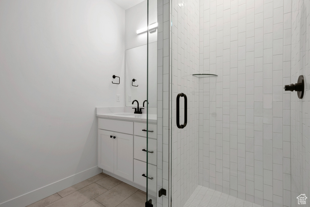 Full bathroom with a stall shower, vanity, and tile patterned floors