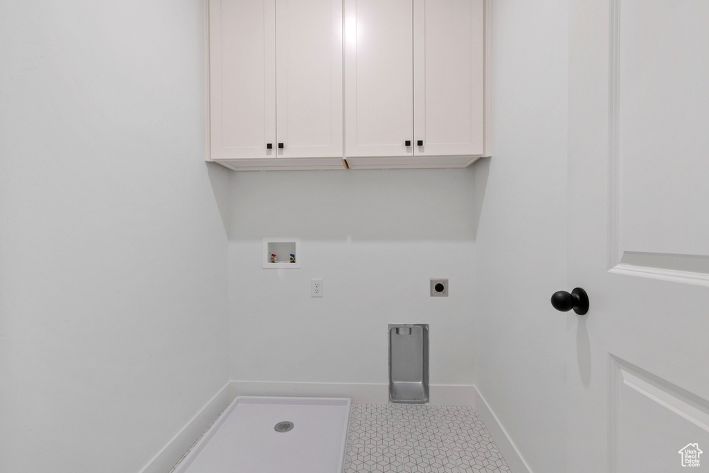 Laundry room with cabinet space, baseboards, hookup for an electric dryer, and hookup for a washing machine