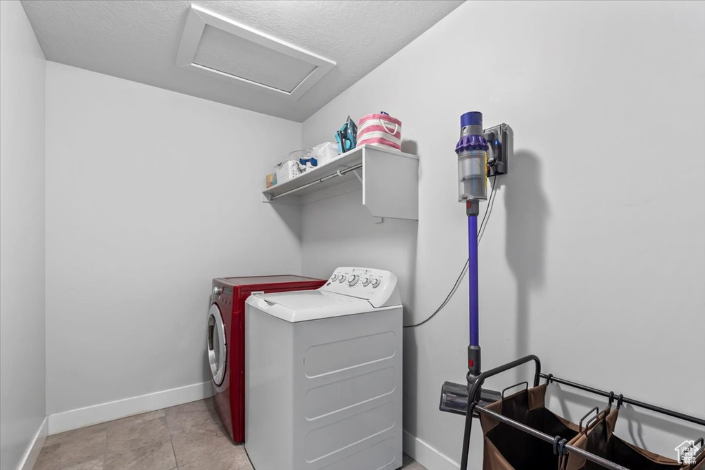 Laundry room featuring attic access, washing machine and clothes dryer, and baseboards