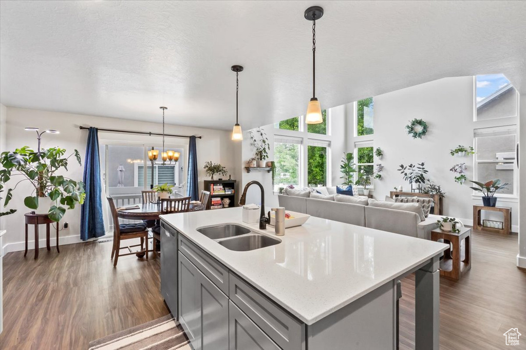 Kitchen featuring a sink, gray cabinetry, dark wood-style flooring, and dishwasher