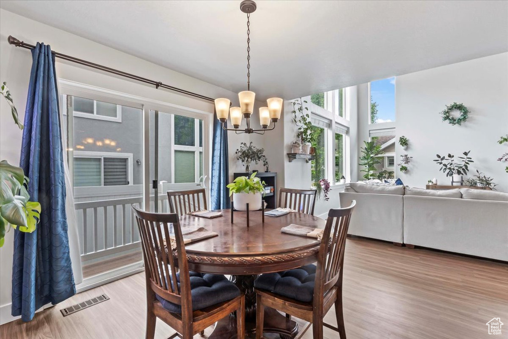 Dining area featuring a chandelier, light wood-style flooring, and plenty of natural light