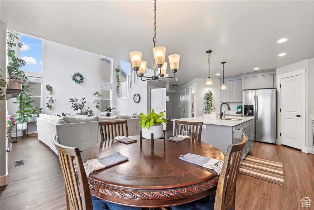 Dining space with wood finished floors, a chandelier, and recessed lighting