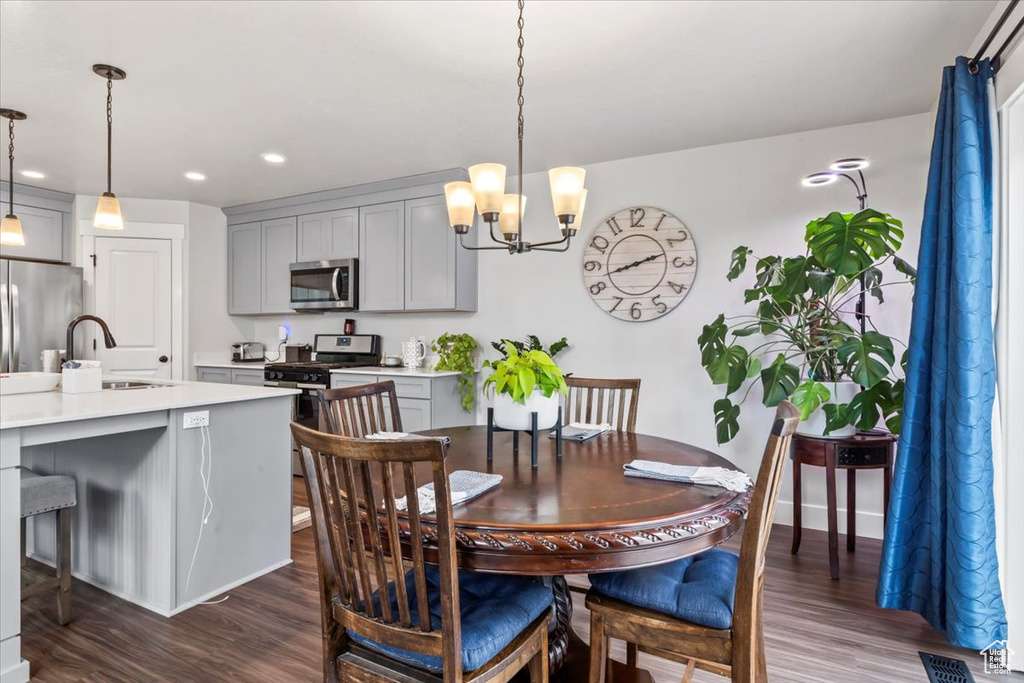 Dining area with dark wood-style flooring, a chandelier, and recessed lighting