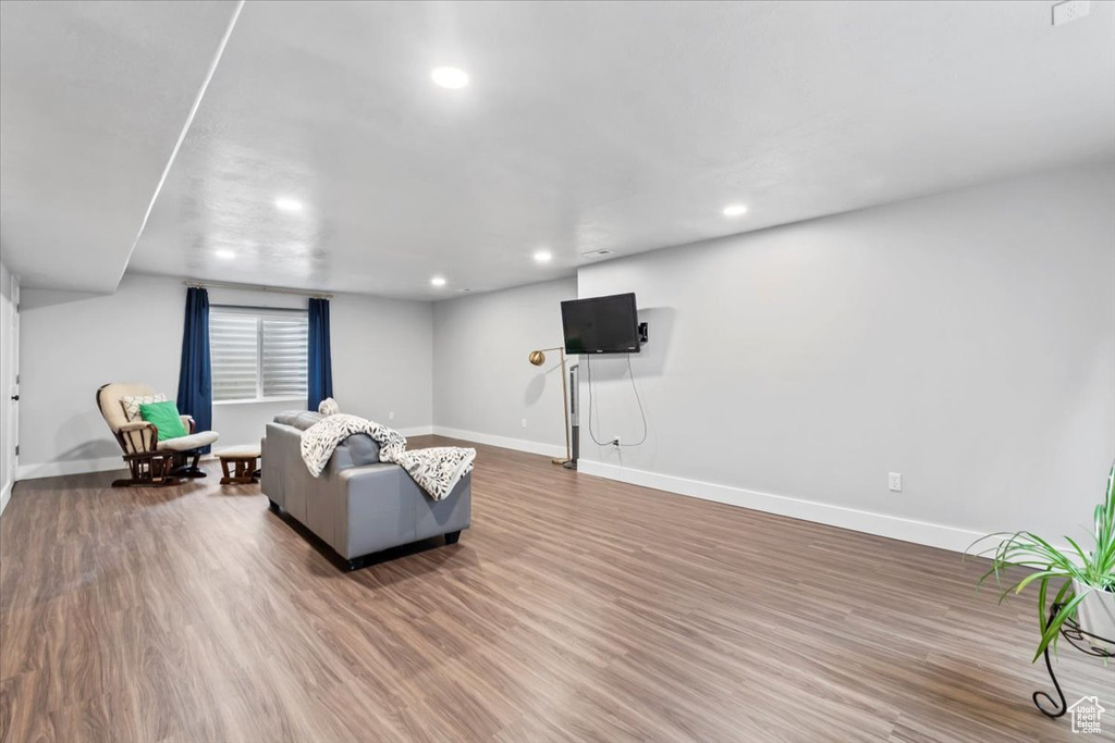 Living room featuring baseboards, wood finished floors, and recessed lighting