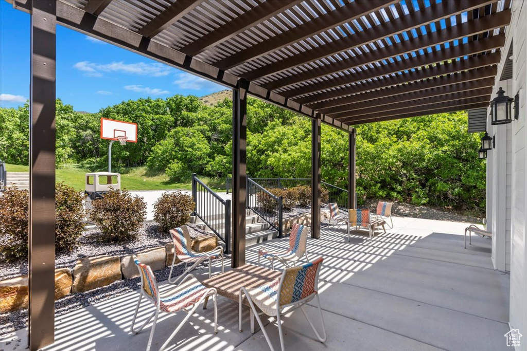 View of patio / terrace featuring a pergola and view of wooded area