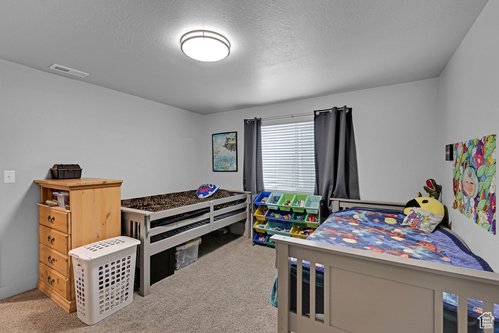 Carpeted bedroom featuring a textured ceiling