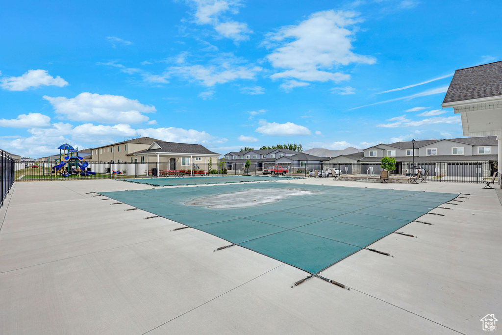 Community pool featuring fence, a residential view, and a patio area