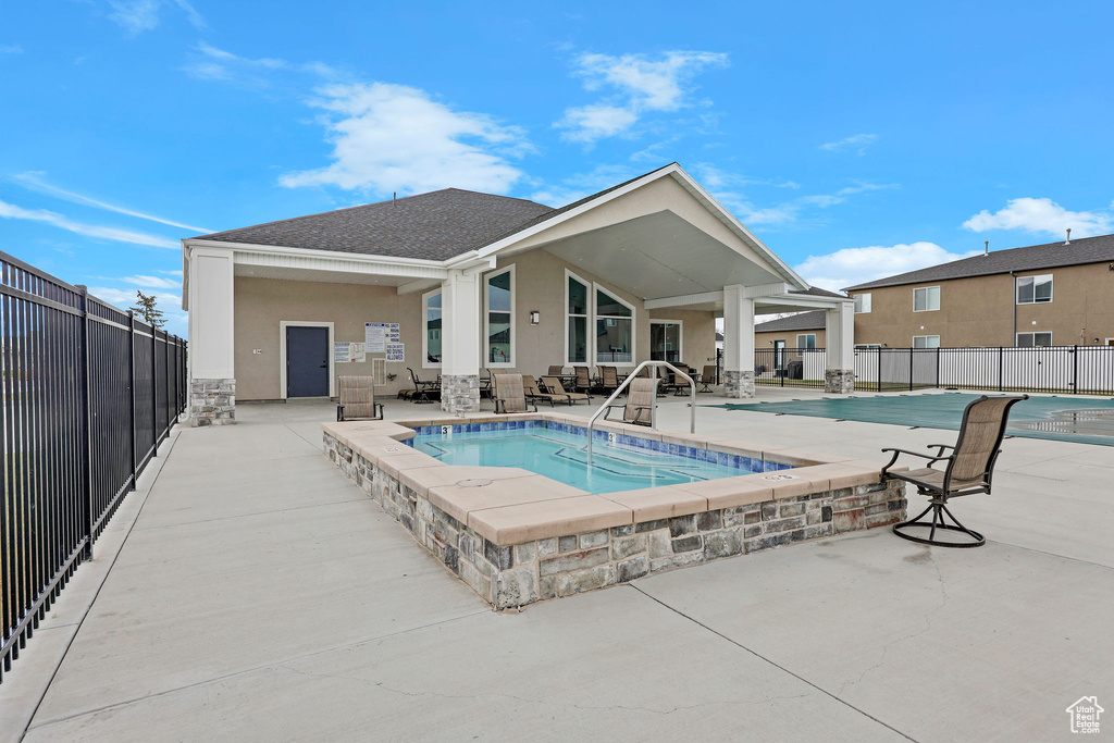 Community pool with a patio and fence