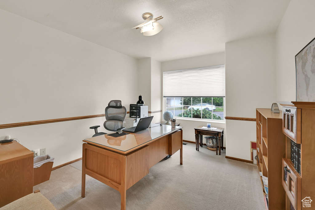Office with light colored carpet and baseboards