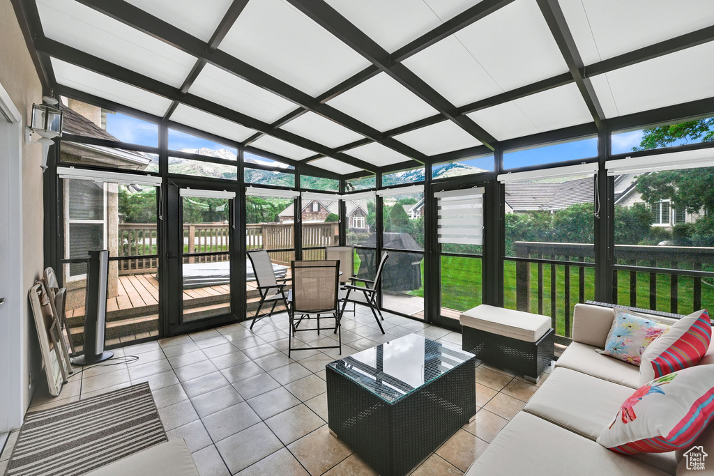 Sunroom / solarium with an outdoor living space, plenty of natural light, lofted ceiling, and outdoor dining space