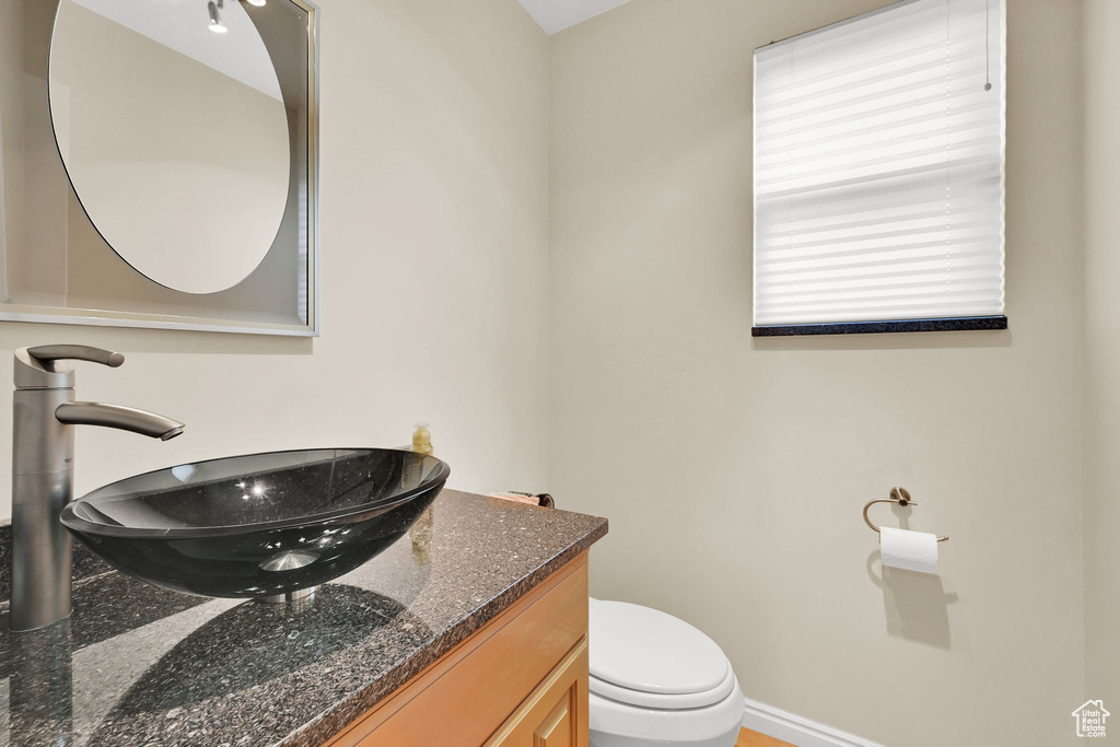 Bathroom with vanity, toilet, and baseboards