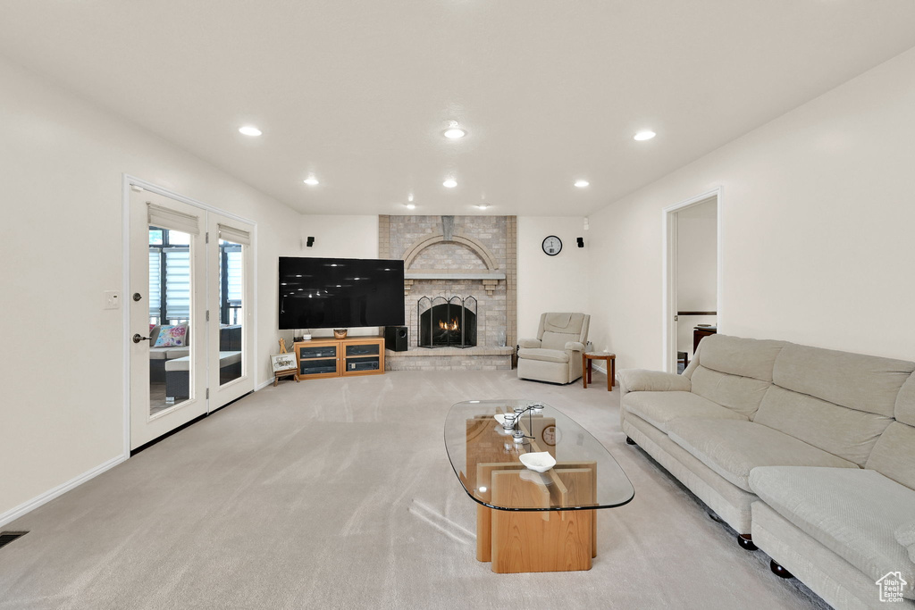 Living room featuring carpet, a fireplace, and recessed lighting