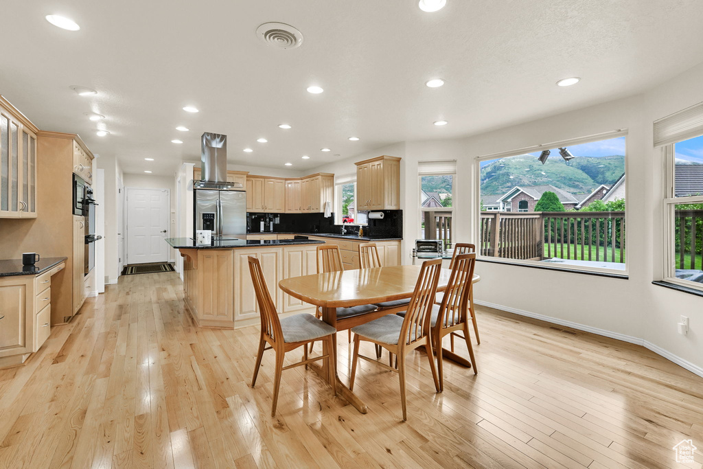 Dining space featuring baseboards, light wood finished floors, and recessed lighting