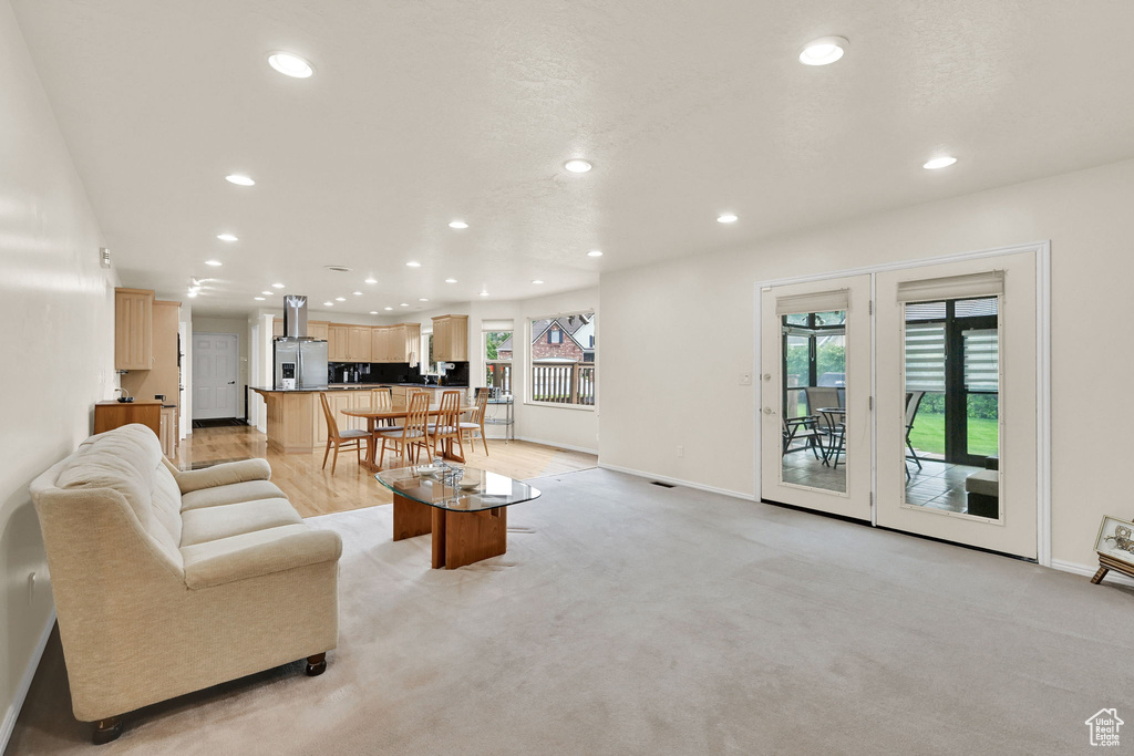 Living room featuring recessed lighting, baseboards, and light carpet