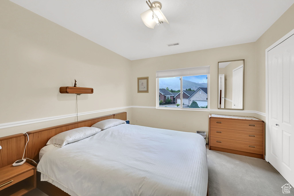 Bedroom with light carpet and a closet