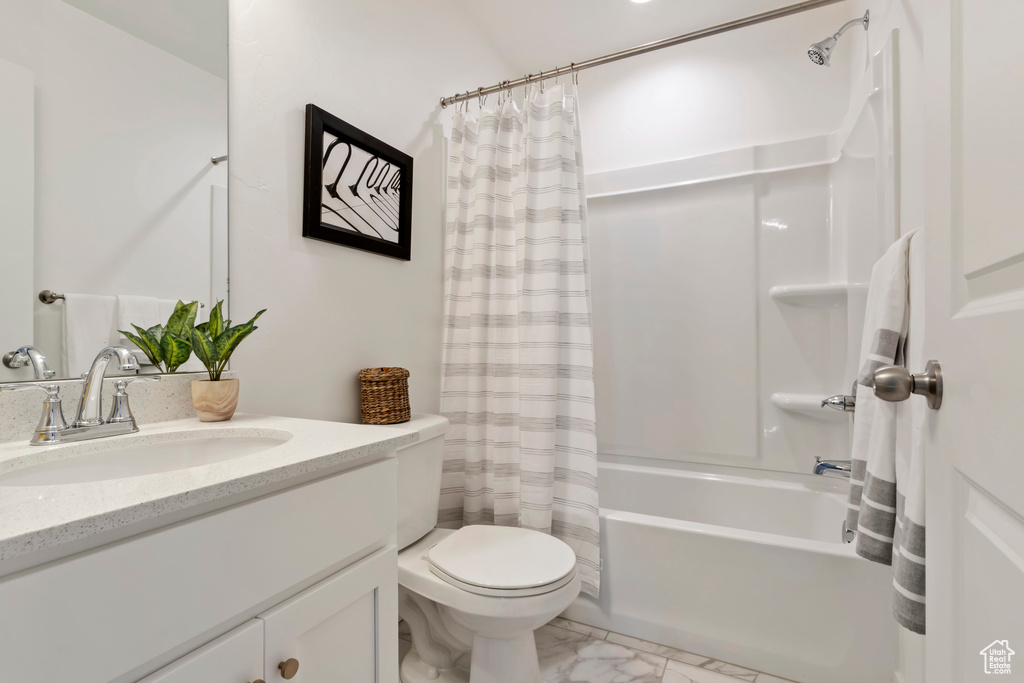 Full bath featuring marble finish flooring, shower / tub combo with curtain, toilet, and vanity
