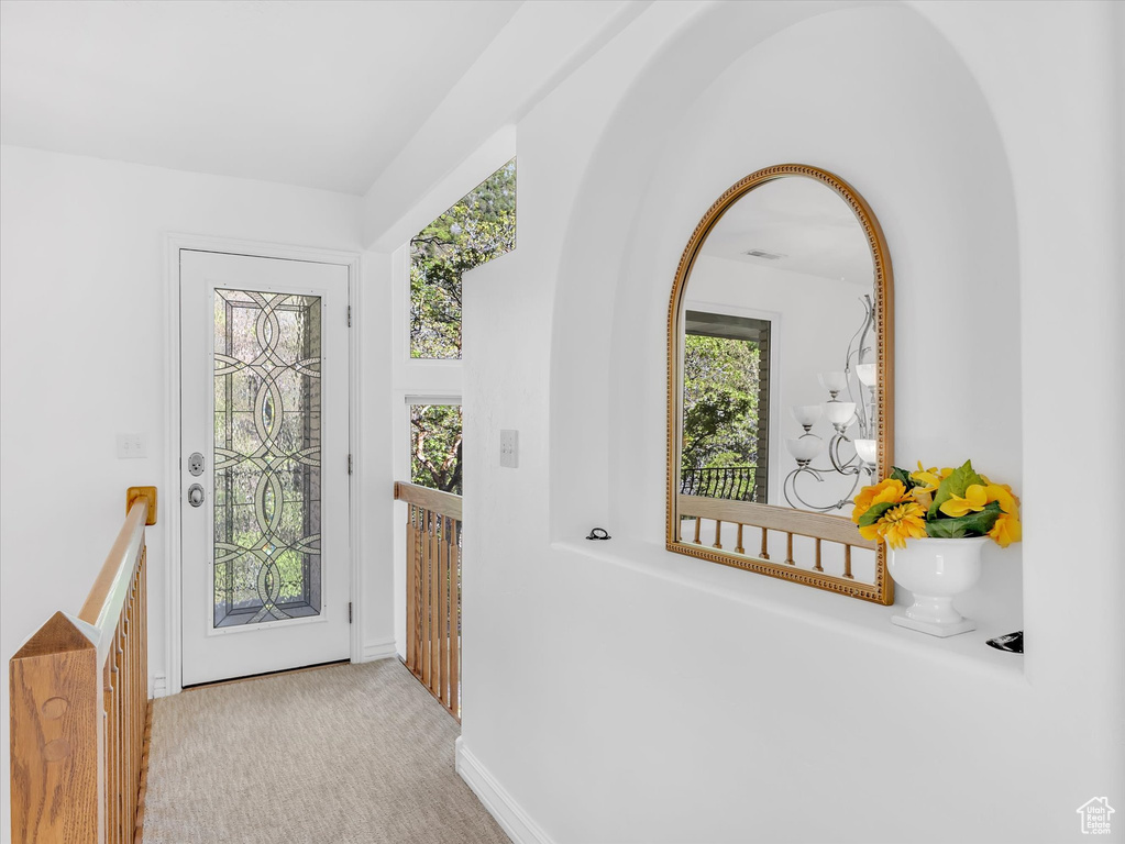 Entryway featuring plenty of natural light, baseboards, and carpet floors