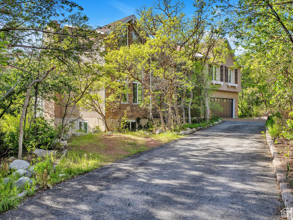 View of front facade featuring an attached garage and asphalt driveway