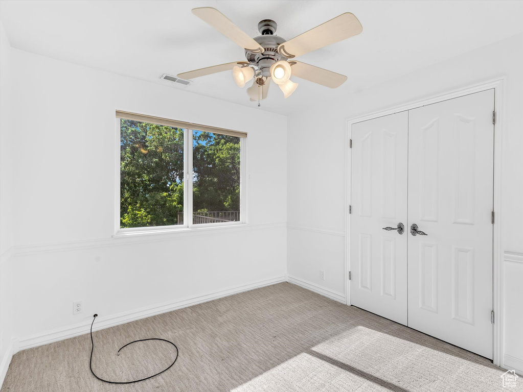 Unfurnished bedroom featuring carpet floors, baseboards, a closet, and ceiling fan