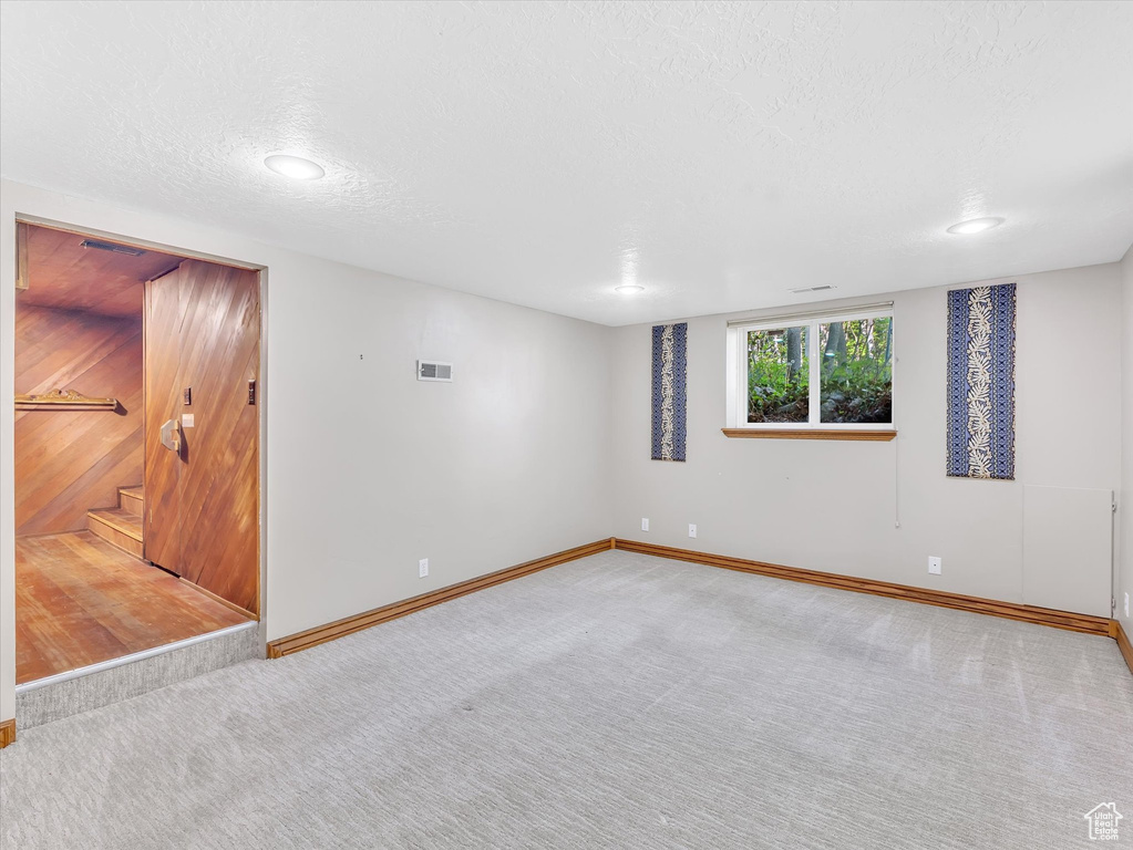 Basement featuring carpet, baseboards, stairway, a textured ceiling, and recessed lighting