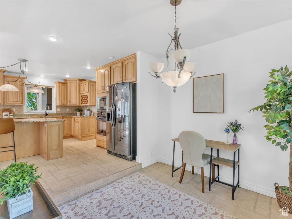 Kitchen featuring black appliances, baseboards, tasteful backsplash, recessed lighting, and a breakfast bar area