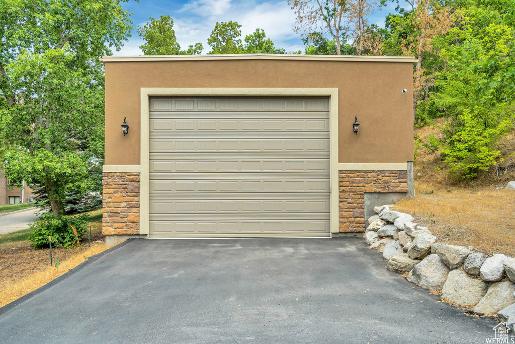 Garage featuring asphalt driveway