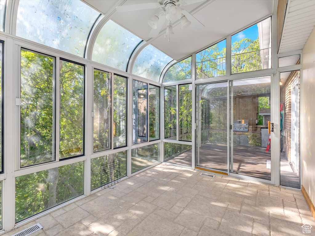 Unfurnished sunroom featuring a ceiling fan and healthy amount of natural light