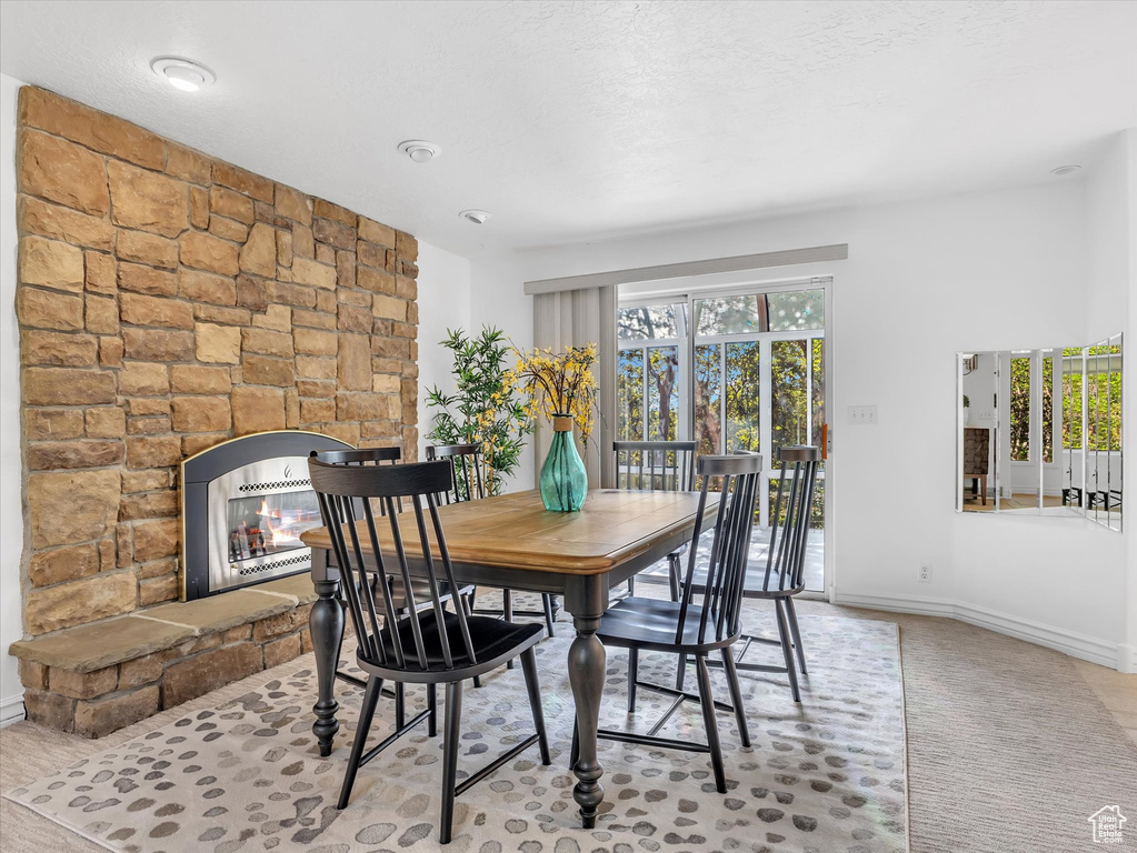 Dining area with a fireplace and baseboards
