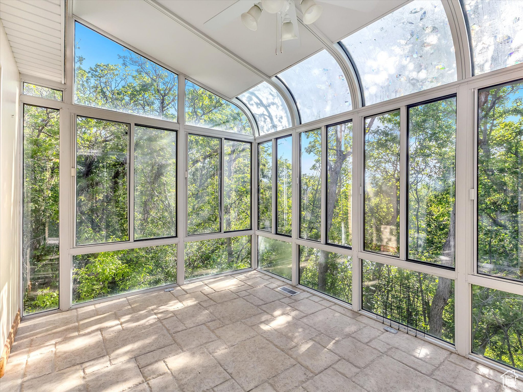 Unfurnished sunroom featuring ceiling fan