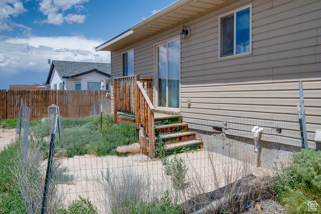 View of exterior entry featuring fence and crawl space